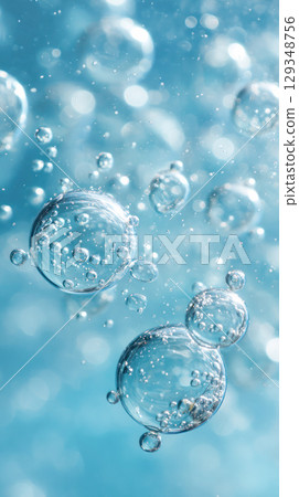 Bubbles rising in clear blue water create a serene underwater scene, showcasing the beauty of nature and the tranquility of aquatic environments 129348756