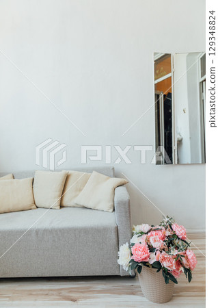Gray sofa and flower basket in white room interior 129348824