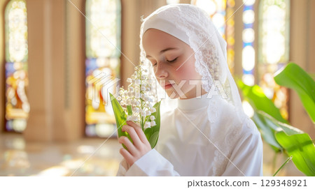 Catholic chrismation ceremony with teenager holding lilies of the valley flowers in church 129348921