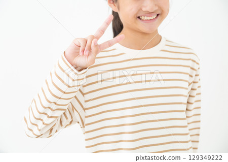 A middle school girl smiling and making a peace sign A middle school girl smiling and making a peace sign 129349222