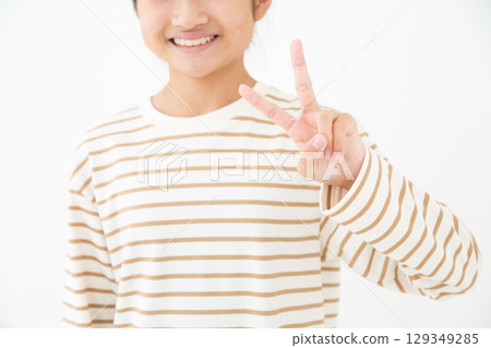 A middle school girl smiling and making a peace sign A middle school girl smiling and making a peace sign 129349285