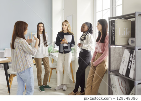 Businesswomen meeting together in office, listening attentively their business leader having seminar 129349386