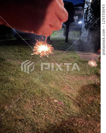 Child's hands enjoying fireworks 129350043