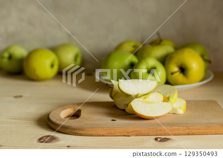 An apple is cut on a wooden board 129350493