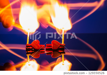Two burning matches on a blue background 129350526