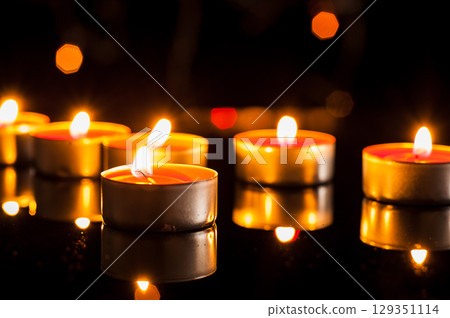 Candle flames tremble in the dark, creating a romantic mood 129351114