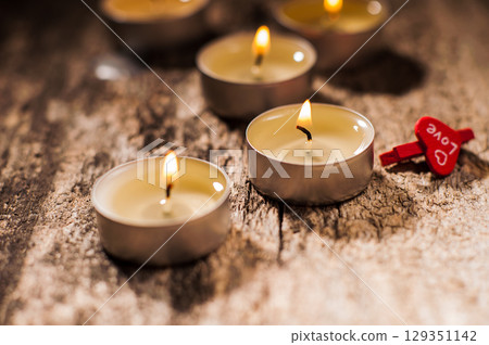 Small candles evenly light up the space around them Small candles evenly light up the space around them 129351142