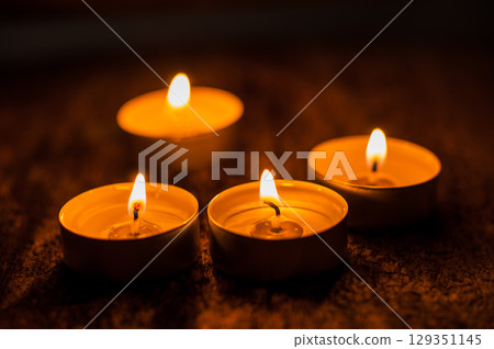 Tealight candles are arranged like a path through the darkness Tealight candles are arranged like a path through the darkness 129351145