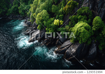 Ocean cliff with lush vegetation and crashing waves below Ocean cliff with lush vegetation and crashing waves below 129351994