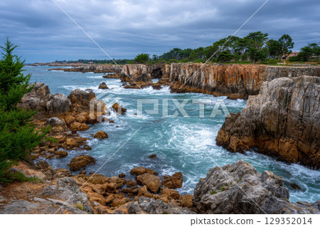 Rugged coastline with crashing waves and dramatic cliffs 129352014