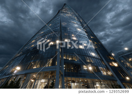 Futuristic skyscraper with twisting design against dusk sky Futuristic skyscraper with twisting design against dusk sky 129352699