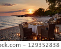 Romantic sunset dining on the beach with seafood risotto 129352838