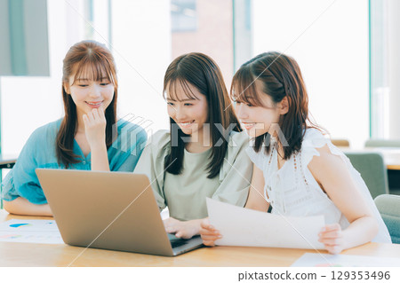 三位女士一邊開會一邊看著電腦 129353496