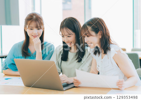 Three women having a meeting while looking at a computer Three women having a meeting while looking at a computer 129353498