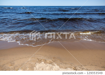 Coastal landscape with sandy ground and shore waves of Lake Ladoga 129353549