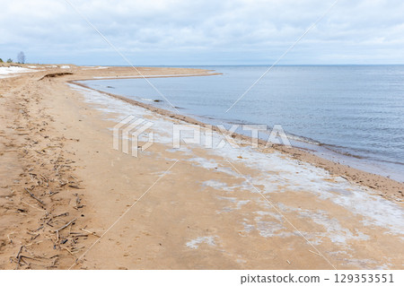 Serene Sandy Beach with Winter Touches and Tranquil Sea Waves Serene Sandy Beach with Winter Touches and Tranquil Sea Waves 129353551