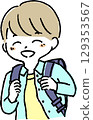 A smiling boy carrying a school bag on his back 129353567