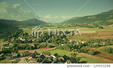 Scenic aerial view of Villard-de-Lans surrounded by Vercors mountains and green fields, heading north Scenic aerial view of Villard-de-Lans surrounded by Vercors mountains and green fields, heading north 129353589