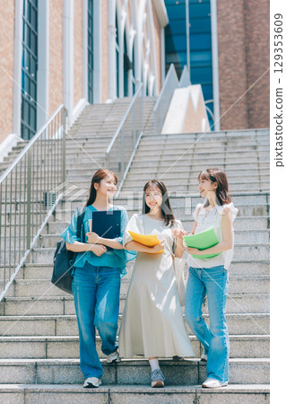 Three college students walking on campus 129353609
