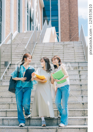 Three college students walking on campus 129353610