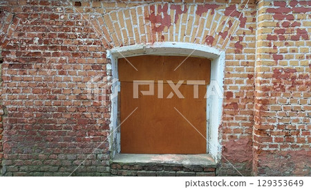 Rustic brick wall with wooden door set in historical building exterior Rustic brick wall with wooden door set in historical building exterior 129353649