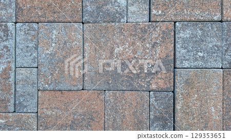 Patterned brick pavement with rustic textured stones in earthy tones 129353651