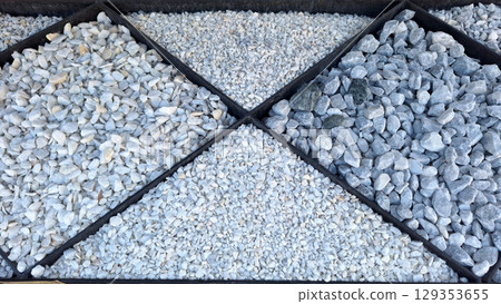 Variety of gravel stones in sectioned display: textures and colors 129353655