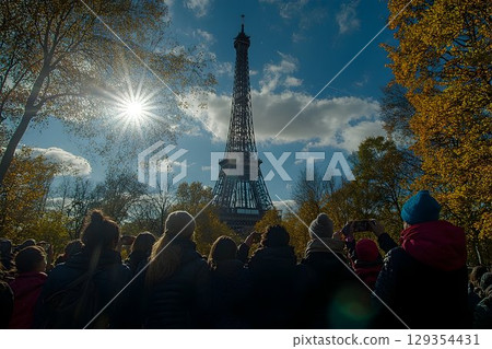 Sunburst over Eiffel Tower with Tourists Capturing the Iconic La Sunburst over Eiffel Tower with Tourists Capturing the Iconic La 129354431
