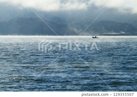 一艘船漂浮在海面上,海霧瀰漫 一艘船漂浮在海面上,海霧瀰漫 129355507