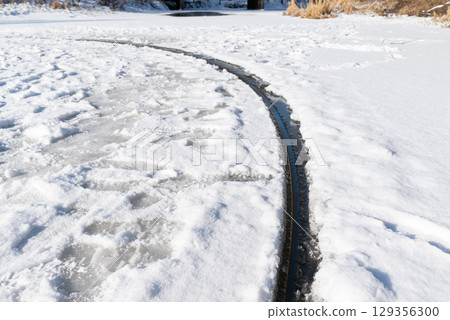 Close up of giant ice circle rotating in river. Rare natural occurrence - perfect ice circle on river in cold winter time 129356300