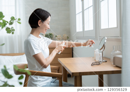 一位女士在手臂上塗抹防紫外線劑 129356329