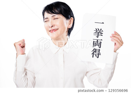 A middle-aged woman happily pumping her fist in a fist while holding a piece of paper that says "kill two birds with one stone" 129356696