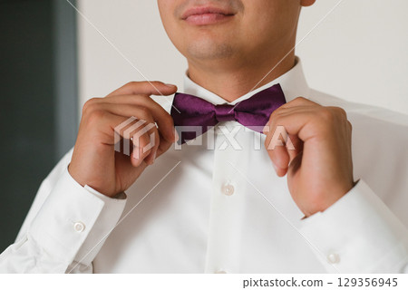 Groom Fixing Purple Bow Tie Before Wedding Groom Fixing Purple Bow Tie Before Wedding 129356945