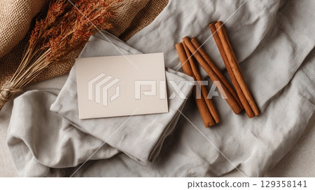 A greeting card against a harvest-style vignette of cinnamon, petals, tea, and candle warmth 129358141