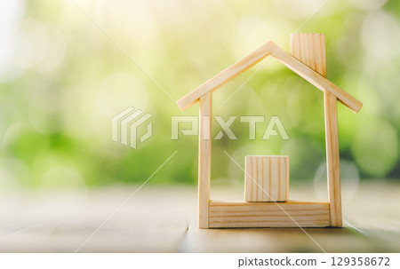 Wooden model house place on the table. concept of real estate investment. planning savings money of coins to buy a home concept for property. Wooden model house place on the table. concept of real estate investment. planning savings money of coins to buy a home concept for property. 129358672