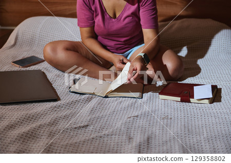 Woman Writing Notes at Home with Notebook, Laptop, and Relaxed Atmosphere Woman Writing Notes at Home with Notebook, Laptop, and Relaxed Atmosphere 129358802