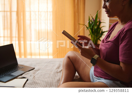Woman Engaged in Remote Work from Home on Digital Devices Woman Engaged in Remote Work from Home on Digital Devices 129358811