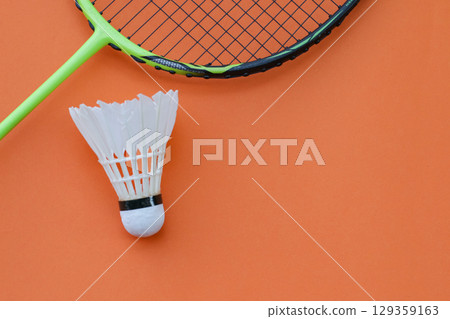 Shuttlecock and Racket on Orange Background Shuttlecock and Racket on Orange Background 129359163