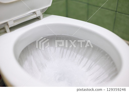 Flushing lavatory pan in toilet. Cleaning toilet after using with water flushing Flushing lavatory pan in toilet. Cleaning toilet after using with water flushing 129359246