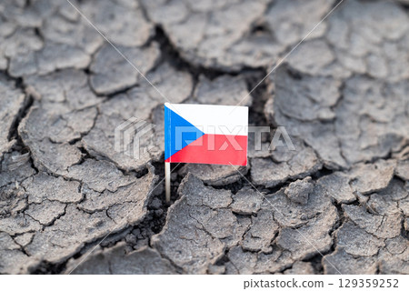 Flag of Czech Republic in dry cracked ground. Concept of drought in Czechia, hot rainless weather 129359252
