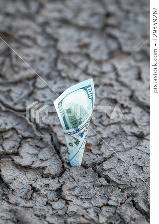 One hundred dollar bill in cracked soil. US currency strong, prepared for unexpected problems, economical crisis, high exchange rate One hundred dollar bill in cracked soil. US currency strong, prepared for unexpected problems, economical crisis, high exchange rate 129359262