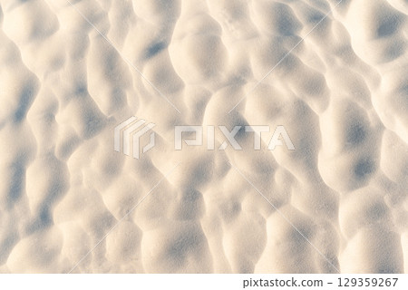 Sand on beach with wavy texture. Close up of sand on the beach with beautiful texture made by wind 129359267
