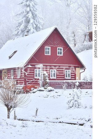 Traditional wooden cottage in a frozen landscape 129359382