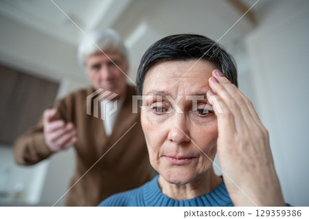 Sad unhappy mature woman enduring verbal aggression from neurotic husband in emotional stress Sad unhappy mature woman enduring verbal aggression from neurotic husband in emotional stress 129359386