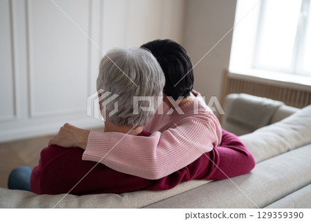 Tender senior couple hugging stroking on sofa. Romantic family warmth comfort emotional relationship Tender senior couple hugging stroking on sofa. Romantic family warmth comfort emotional relationship 129359390