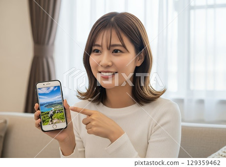 一位年輕女子向別人展示她用智慧型手機拍攝的照片 一位年輕女子向別人展示她用智慧型手機拍攝的照片 129359462