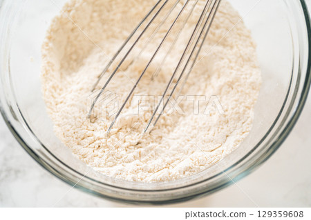 A glass mixing bowl filled with a blend of all-purpose flour, baking powder, salt, and cream of tartar, ready to be whisked together for making lemon spritz cookies. Combining dry ingredients A glass mixing bowl filled with a blend of all-purpose flour, baking powder, salt, and cream of tartar, ready to be whisked together for making lemon spritz cookies. Combining dry ingredients 129359608