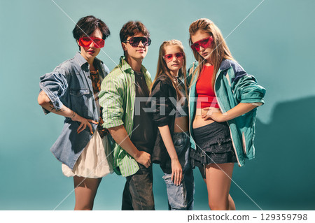 Confident group of trendy youth posing in bold streetwear and colorful sunglasses on turquoise background Confident group of trendy youth posing in bold streetwear and colorful sunglasses on turquoise background 129359798