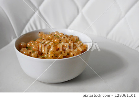 Fresh Yellow Currants in a White Bowl on White Background 129361101