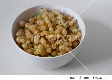 Fresh Yellow Currants in a White Bowl on White Background 129361102